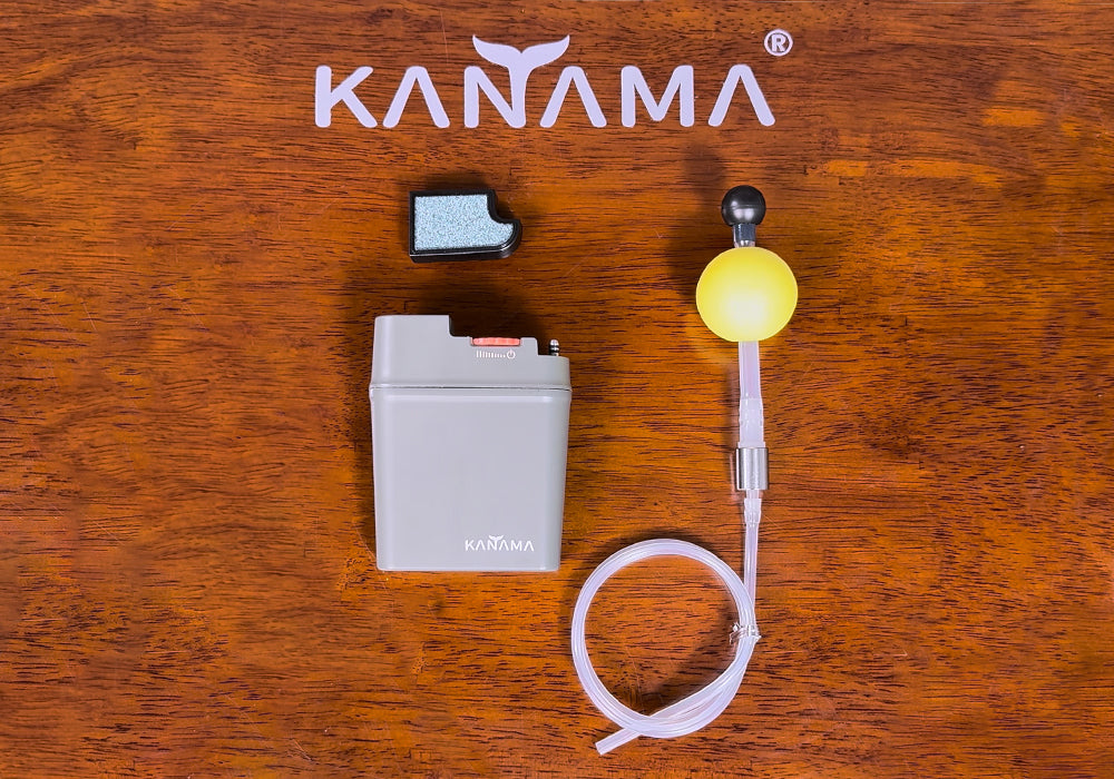 Kanama battery and accessories on a wooden surface
