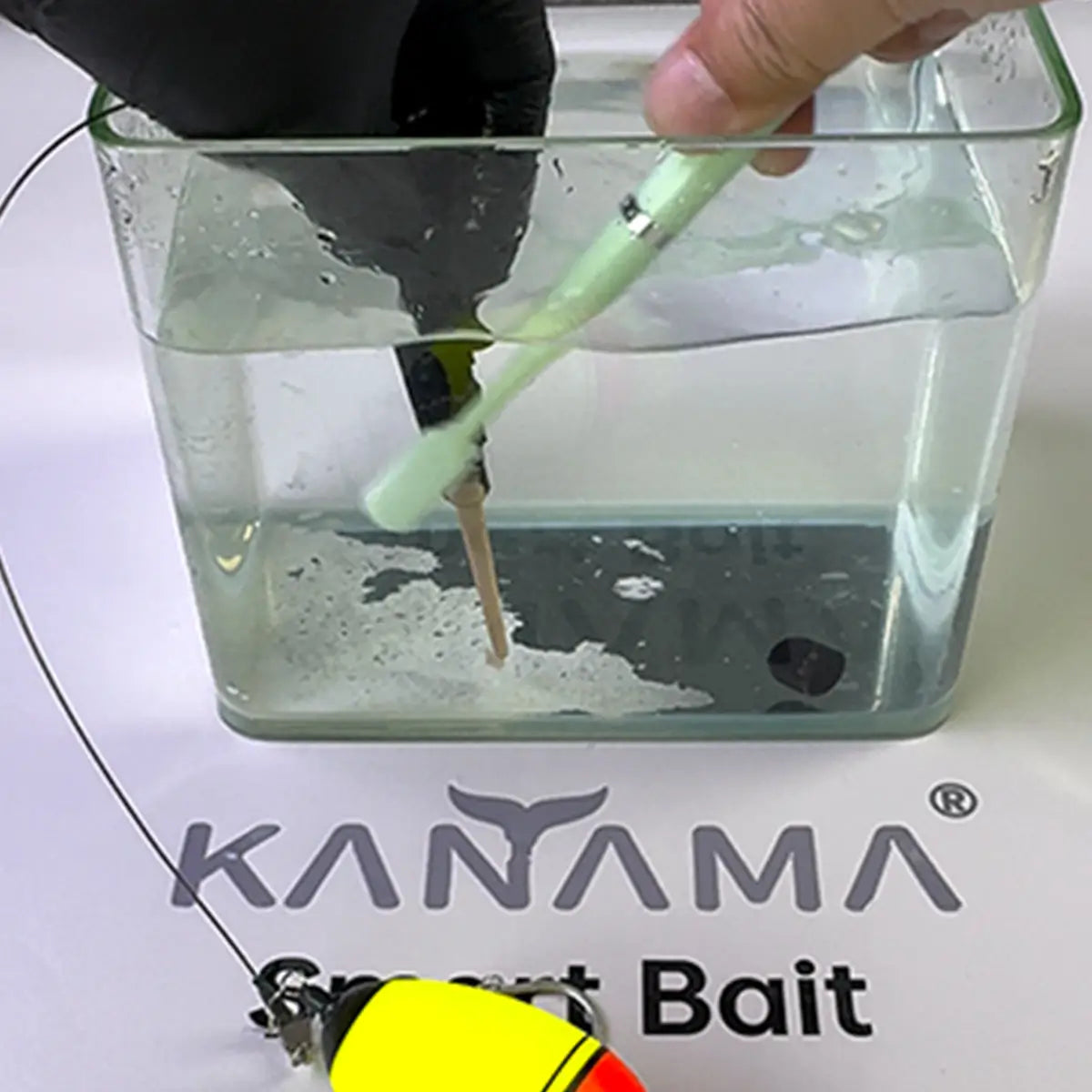 Person using a brush to clean smart bait in a container