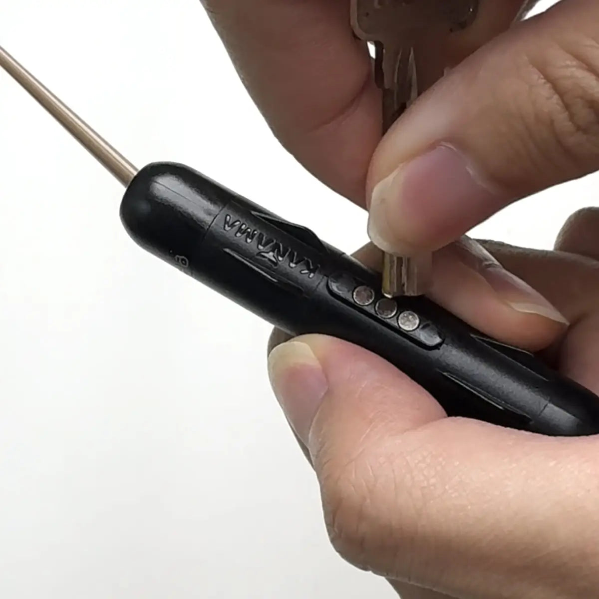 Hand holding a black smart bait with a white background